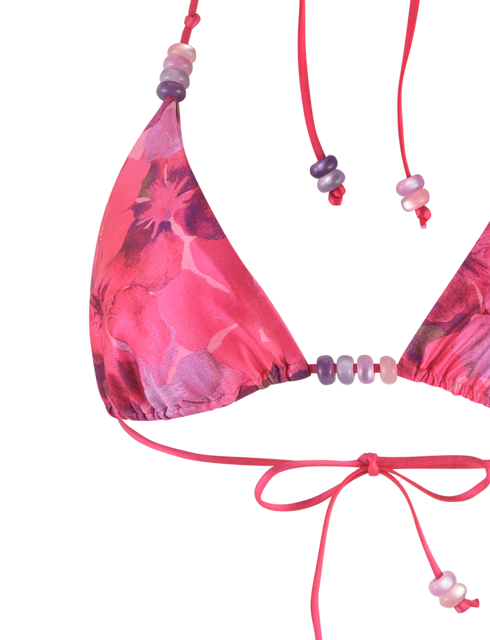Close-up of the TIGERMIST FINLEA BIKINI TOP - PINK : HIBISCUS, featuring a pink hibiscus floral print, string ties, and decorative beads for adjustable styling.