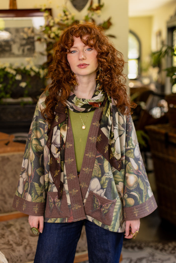 Model wearing a cozy cardigan lined with fleece featuring vintage magnolia lithographs, delicate moth etchings, and charming bumblebee trim - Market of stars