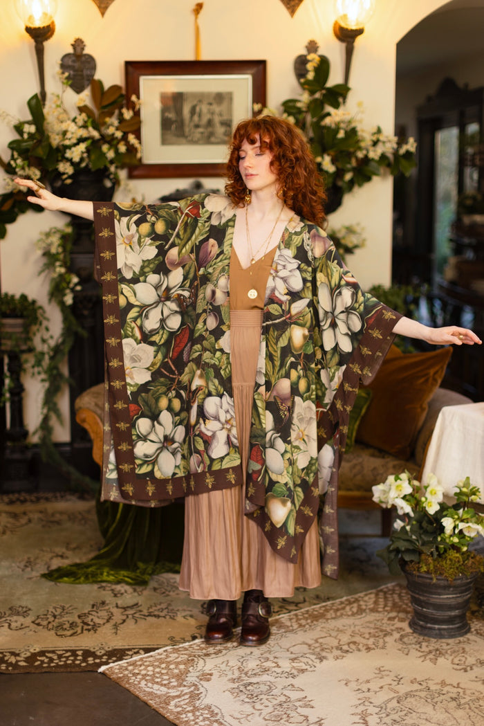 Model wearing a flowy kimono duster featuring vintage magnolia lithographs, delicate moth etchings, and charming bumblebee trim - Market of Stars