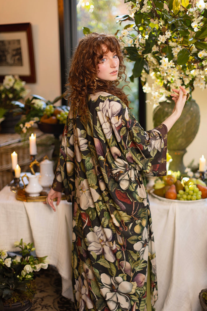 Model wearing a full length kimono duster robe featuring vintage magnolia lithographs, delicate moth etchings, and charming bumblebee trim - Market of Stars