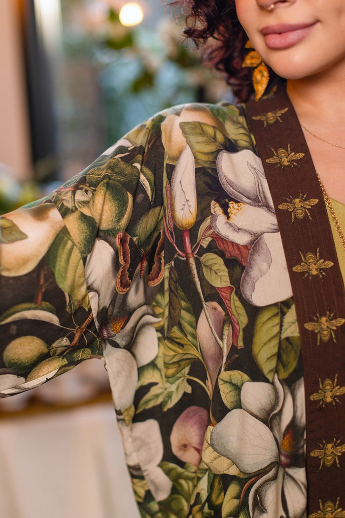 Model wearing a cropped kimono duster featuring vintage magnolia lithographs, delicate moth etchings, and charming bumblebee trim - Market of Stars