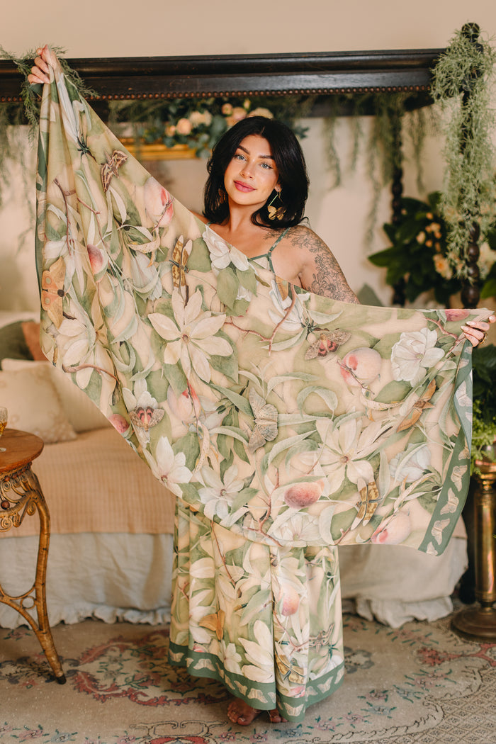 Model wearing a bamboo viscose scarf inspired by antique florals, butterflies, and sunlit gardens, this flowing duster captures the warmth and magic of golden hour - Market of Stars