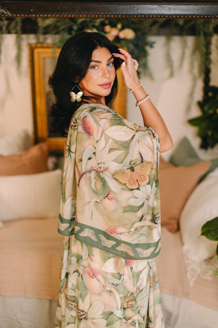 Model wearing a bamboo viscose scarf inspired by antique florals, butterflies, and sunlit gardens, this flowing duster captures the warmth and magic of golden hour - Market of Stars