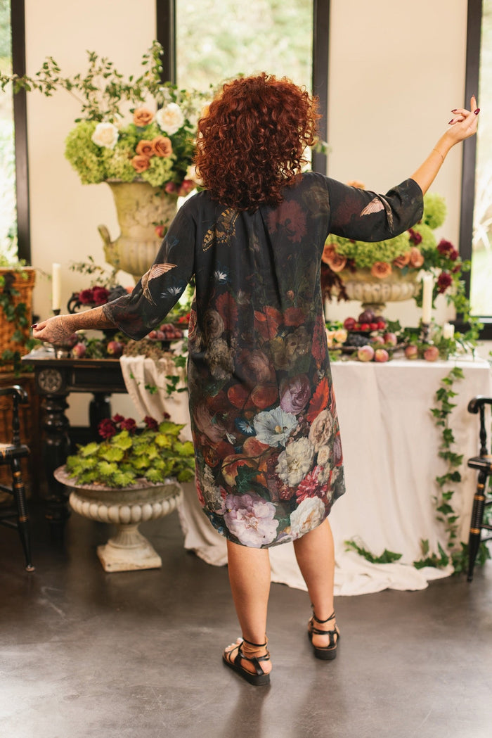 Model wearing the Flight of Fancy Artist Dress featuring vintage floral paintings and a bouquet of hummingbirds symbolizing hope and joy – Market of Stars.