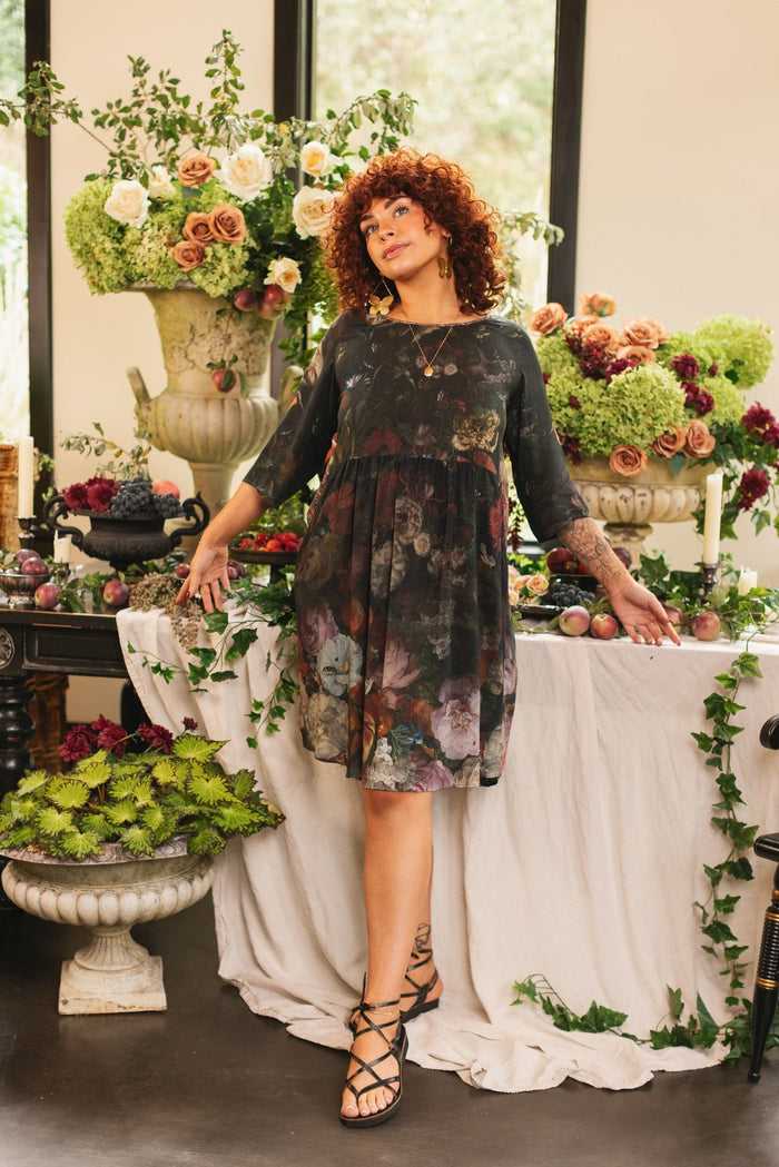 Model wearing the Flight of Fancy Artist Dress featuring vintage floral paintings and a bouquet of hummingbirds symbolizing hope and joy – Market of Stars.