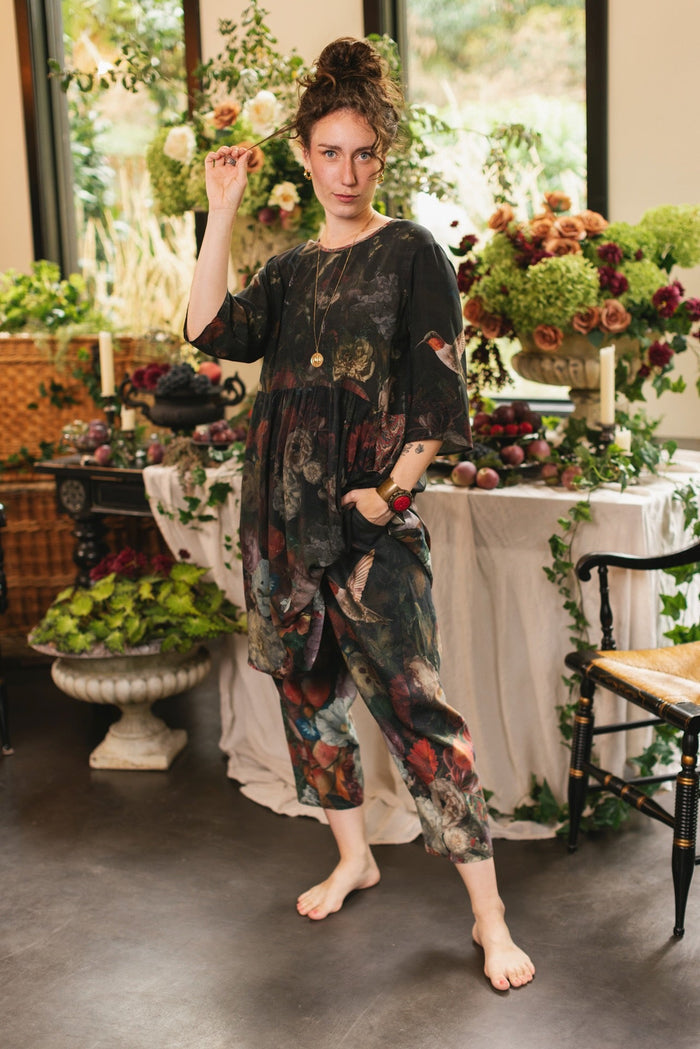 Model wearing the Flight of Fancy Artist Dress featuring vintage floral paintings and a bouquet of hummingbirds symbolizing hope and joy – Market of Stars.