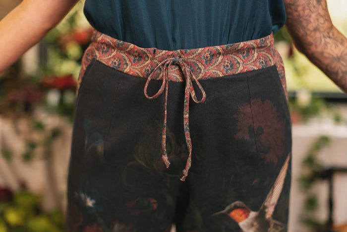 Model wearing the Folklore Artist Pant featuring the Bird-of-Peace embroidery and unfinished William Morris textile designs—artful linen blend pants by Market of Stars.