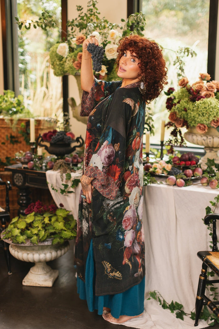 Model showcasing the Flight of Fancy Opera Robe featuring vibrant hummingbirds and historic floral paintings by Rachel Ruysch – Market of Stars.