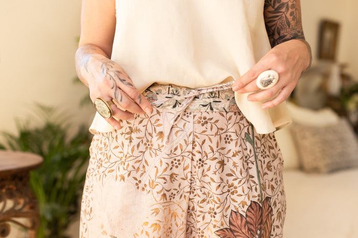 Model wearing Folklore Artist Pants featuring hand-stitched Bird-of-Peace embroidery and unfinished William Morris artwork celebrating the beauty of the artistic process – Market of Stars.