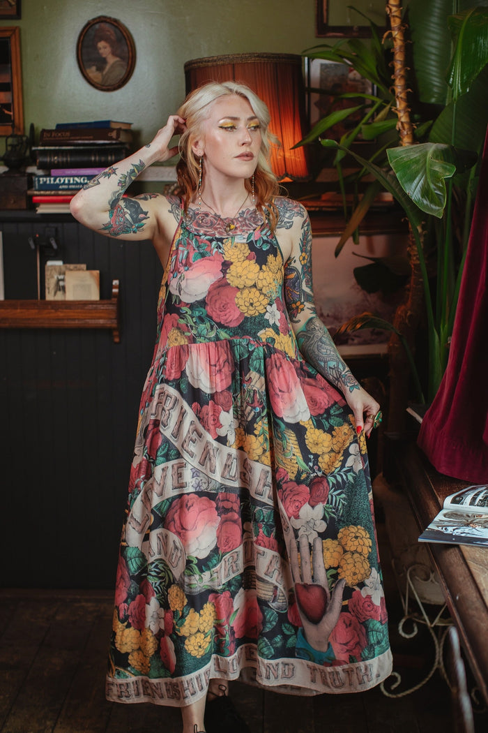Model wearing reversible bamboo viscose slip dress featuring vintage symbols of friendship, love, and truth with pink and rose palette – Market of Stars.