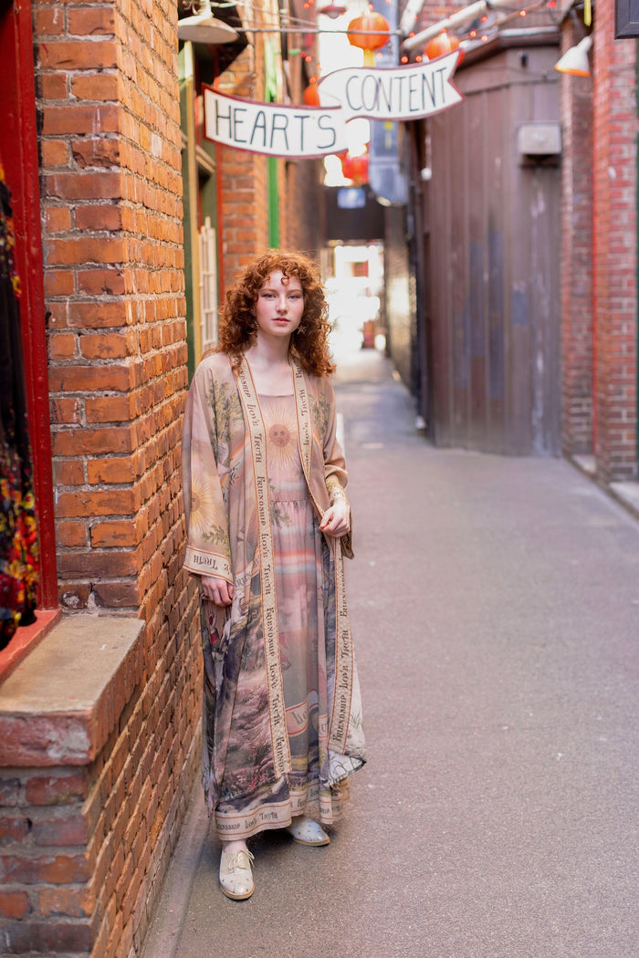 Model wearing sun-washed vintage-inspired Opera Duster featuring symbols of friendship, love, and truth in soft lavender, sage, gold, and aqua – Market of Stars