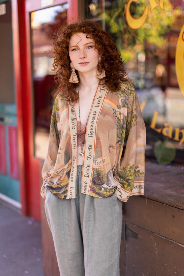 Vintage-inspired cropped kimono featuring historic symbols of friendship, love, and truth in a soft sun-washed palette of lavender, sage, gold, and aqua – Market of Stars.