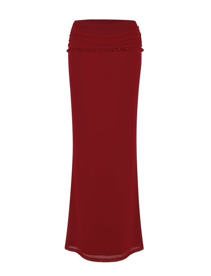 The GINNY MAXI SKIRT - RED : CHERRY RED by TIGERMIST is a long, flowy skirt with a high waistband and subtle ruffle detail near the top. Featuring maxi length and made from stretchy fabric, the skirt extends straight down, creating a sleek and elegant silhouette.