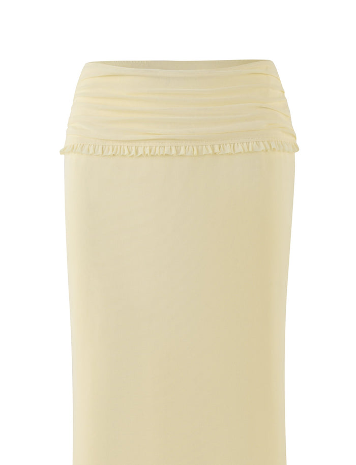 The GINNY MAXI SKIRT - YELLOW : LEMON by TIGERMIST showcases a light yellow color with a ruched wide waistband and delicate ruffle details at the top. Its soft, stretchy fabric creates a simple and elegant appearance against a plain white background.