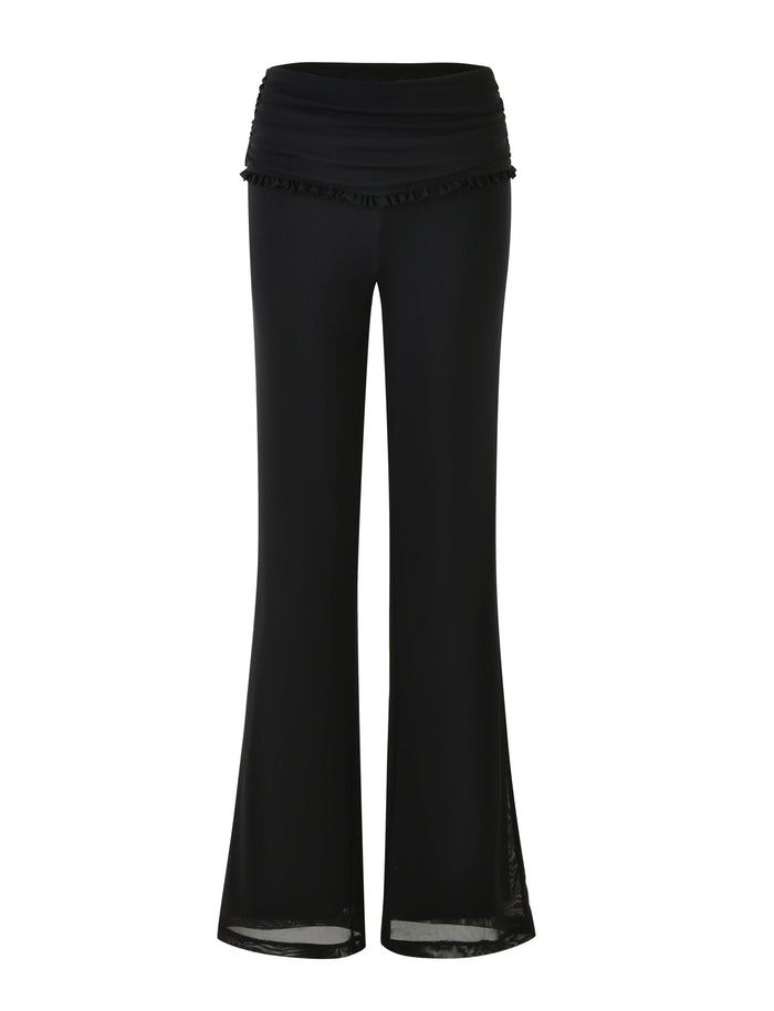 The GINNY PANT - BLACK by TIGERMIST features a high, ruched waistband adorned with a small ruffle detail. These women's pants boast wide legs that create a flared silhouette and are crafted from lightweight, flowing fabric.