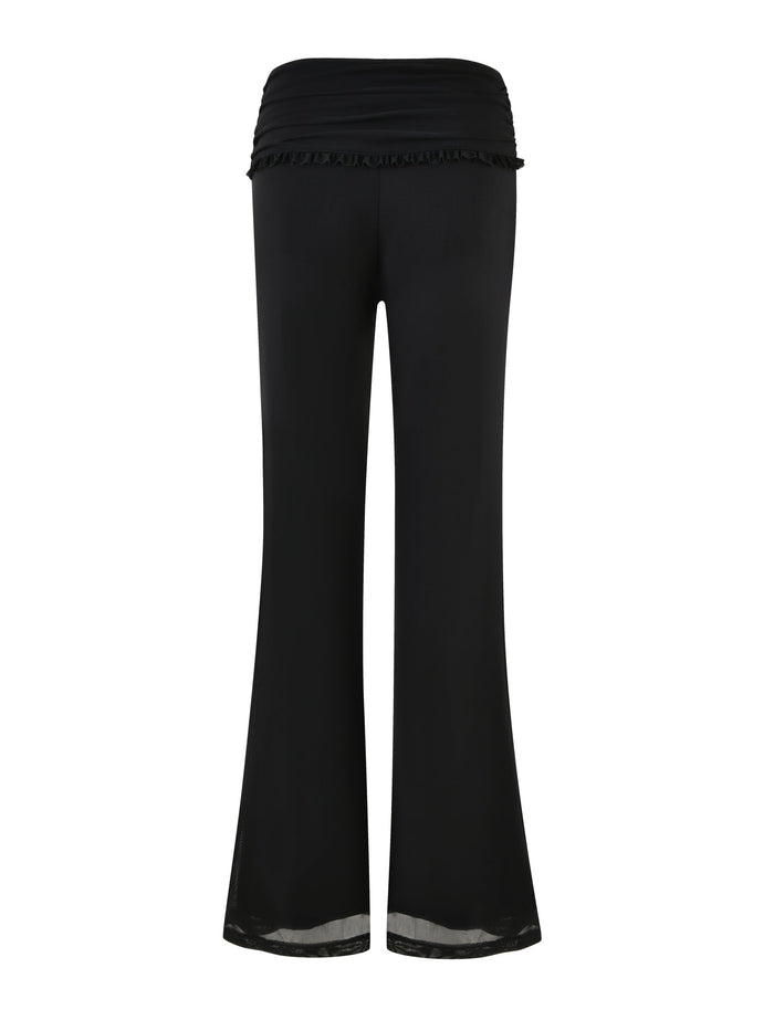 A pair of GINNY PANT - BLACK from TIGERMIST displayed from the back. These women's trousers feature a flared silhouette at the bottom and a ruched waistband. Made from lightweight, flowy fabric, they boast a low-rise waist and offer a casual, comfortable style.
