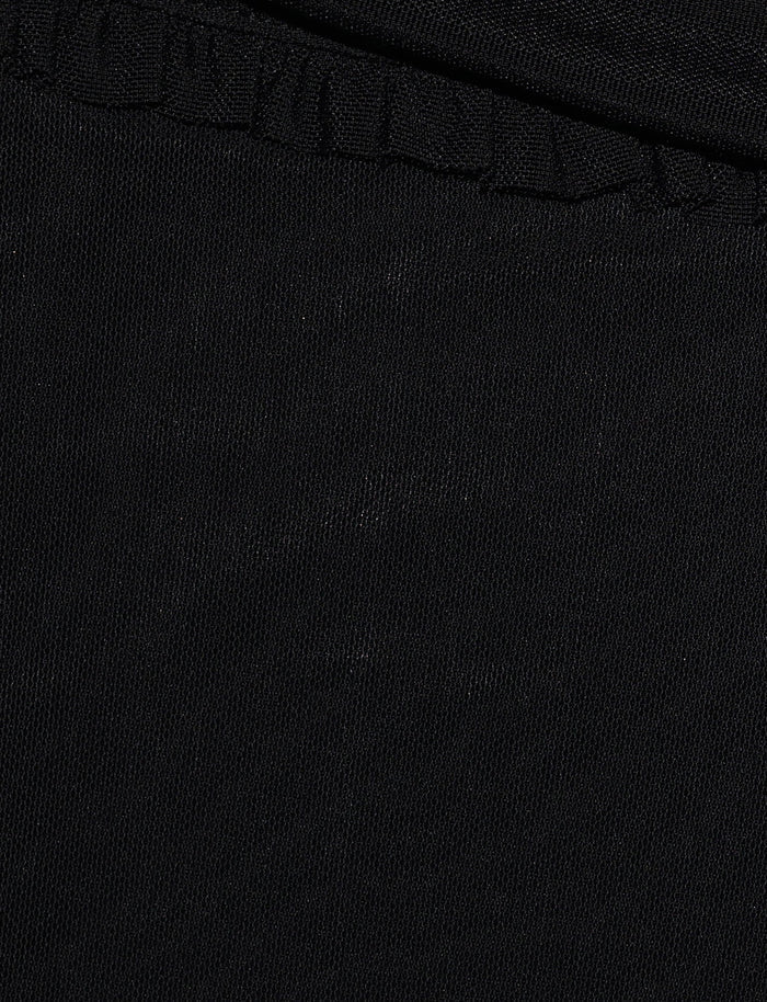 Close-up of a black fabric with a slightly textured surface. The top part of the image features a seam with gathering, hinting at the GINNY PANT - BLACK by TIGERMIST, suggesting a short or flared silhouette in the garment. The fabric appears smooth and is uniformly black throughout.