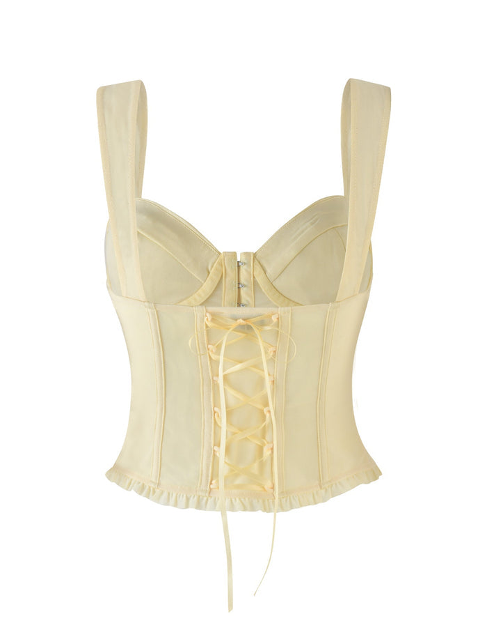 Back view of a lemon yellow GINNY TOP by TIGERMIST, featuring wide straps and lace-up detail. The top boasts a slight ruffle trim at the hem, evoking a vintage-inspired aesthetic complemented by its subtle sweetheart neckline charm.