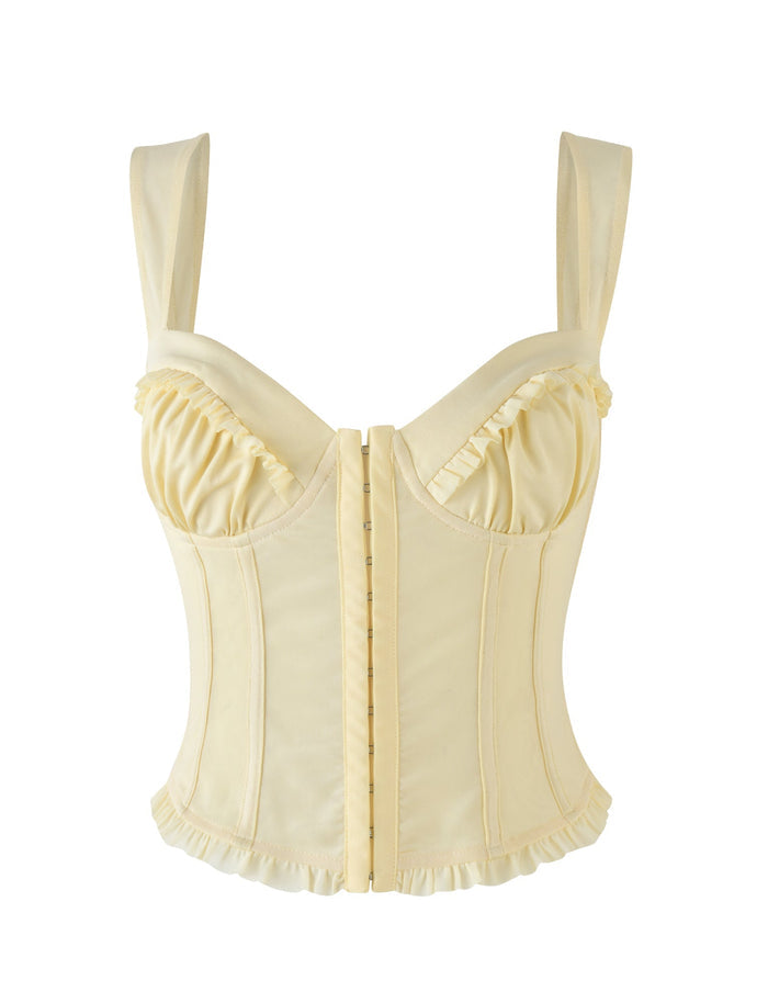 The Ginny Top in a lemon-yellow shade by Tigermist is a corset-style garment featuring wide shoulder straps and decorative ruffles along the bust and bottom hem. It has a sweetheart neckline and hook-and-eye closures, and its satin-like fabric enhances a bodycon silhouette for an elegant finish.
