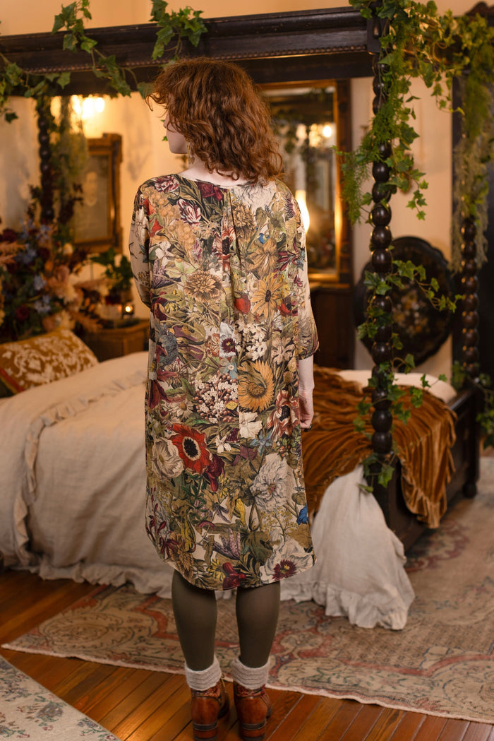 Model wearing a soft bamboo-viscose knee-length dress featuring rich 1700s botanical blooms and swallow trim - Market of Stars