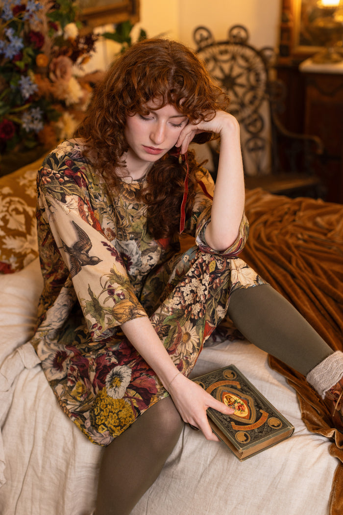 Model wearing a soft bamboo-viscose knee-length dress featuring rich 1700s botanical blooms and swallow trim - Market of Stars