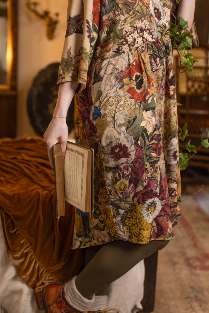 Model wearing a soft bamboo-viscose knee-length dress featuring rich 1700s botanical blooms and swallow trim - Market of Stars