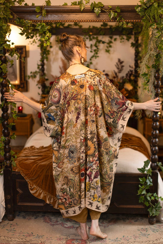 Model wearing a soft bamboo-viscose flowy duster featuring rich 1700s botanical blooms and swallow trim - Market of Stars