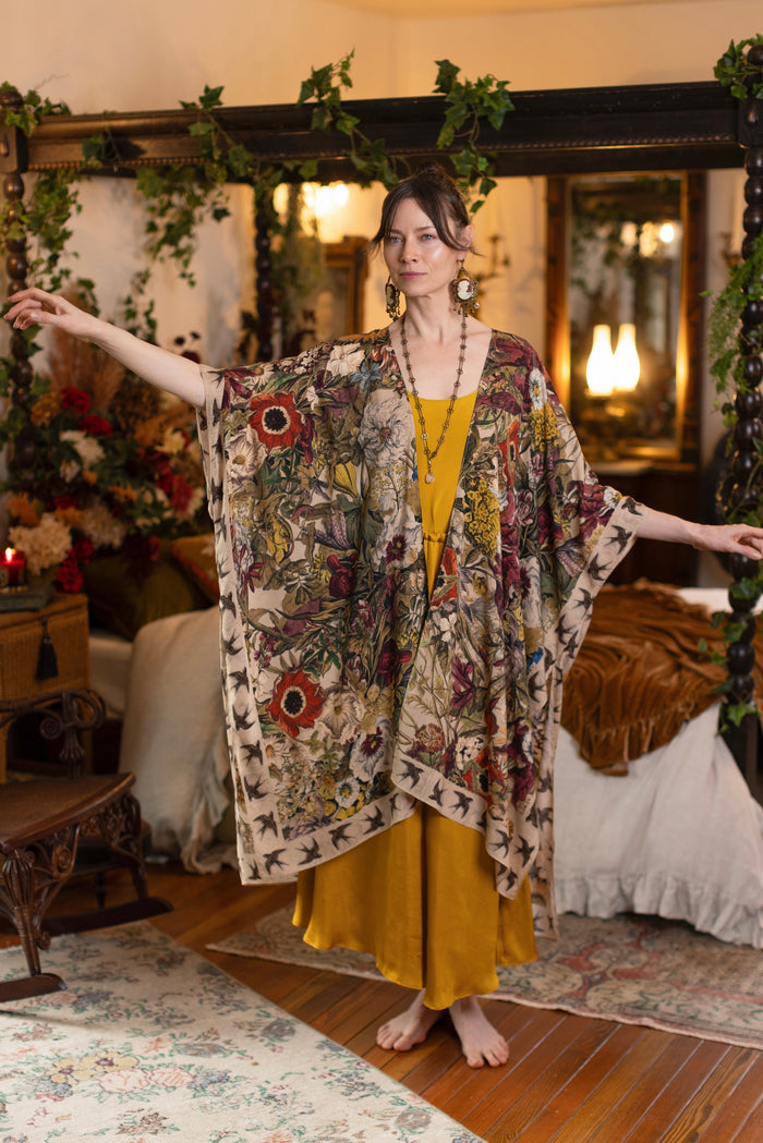 Model wearing a soft bamboo-viscose flowy duster featuring rich 1700s botanical blooms and swallow trim - Market of Stars