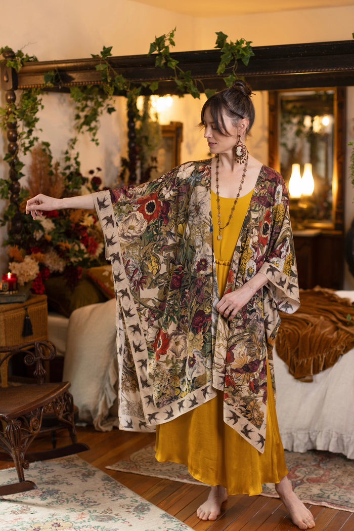 Model wearing a soft bamboo-viscose flowy duster featuring rich 1700s botanical blooms and swallow trim - Market of Stars