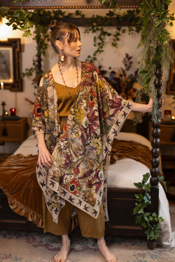 Model wearing a soft bamboo-viscose flowy duster featuring rich 1700s botanical blooms and swallow trim - Market of Stars
