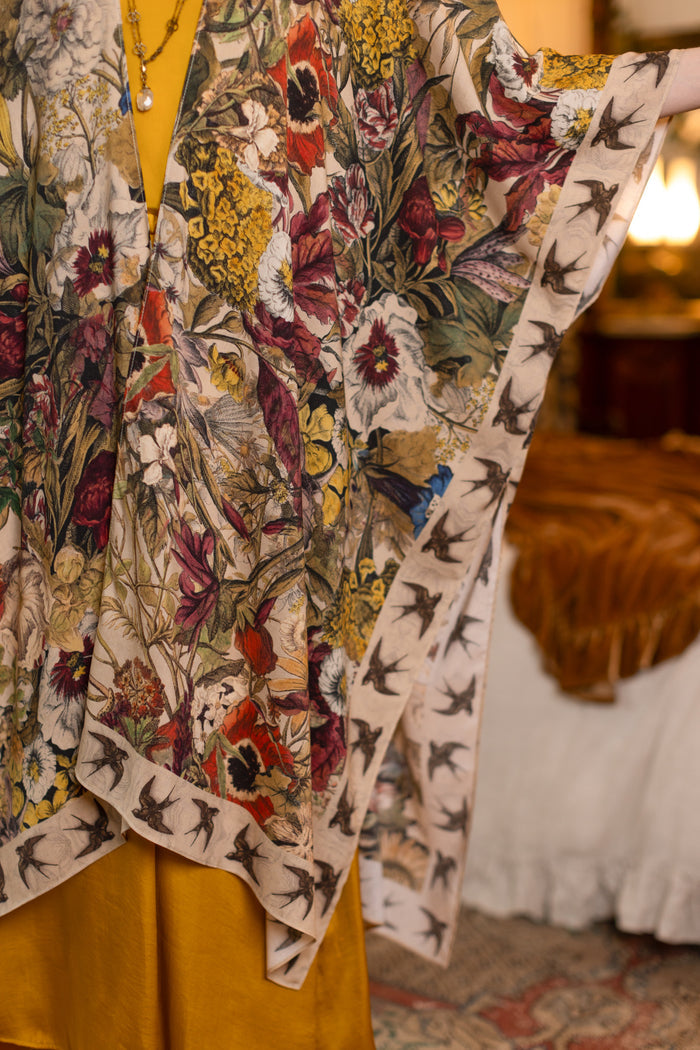 Model wearing a soft bamboo-viscose flowy duster featuring rich 1700s botanical blooms and swallow trim - Market of Stars