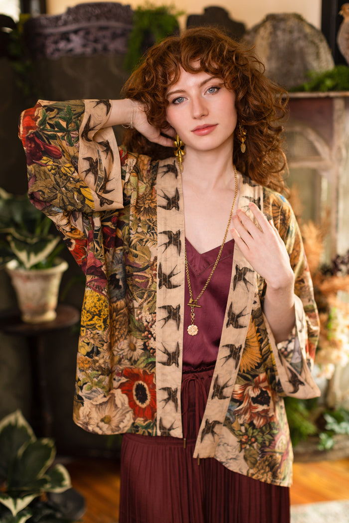Model wearing a soft bamboo-viscose cropped duster featuring rich 1700s botanical blooms and swallow trim - Market of Stars