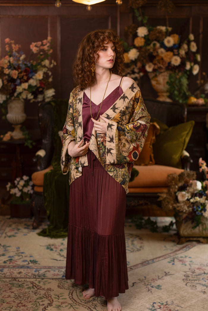 Model wearing a soft bamboo-viscose cropped duster featuring rich 1700s botanical blooms and swallow trim - Market of Stars
