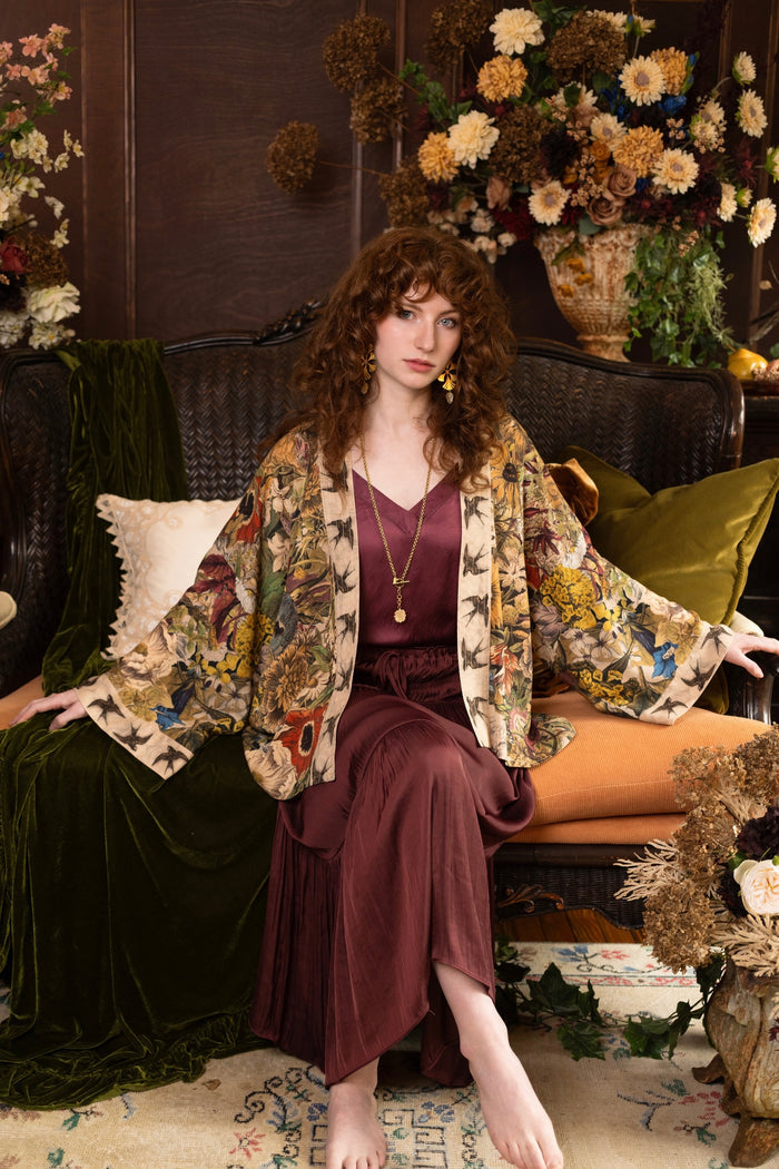 Model wearing a soft bamboo-viscose cropped duster featuring rich 1700s botanical blooms and swallow trim - Market of Stars