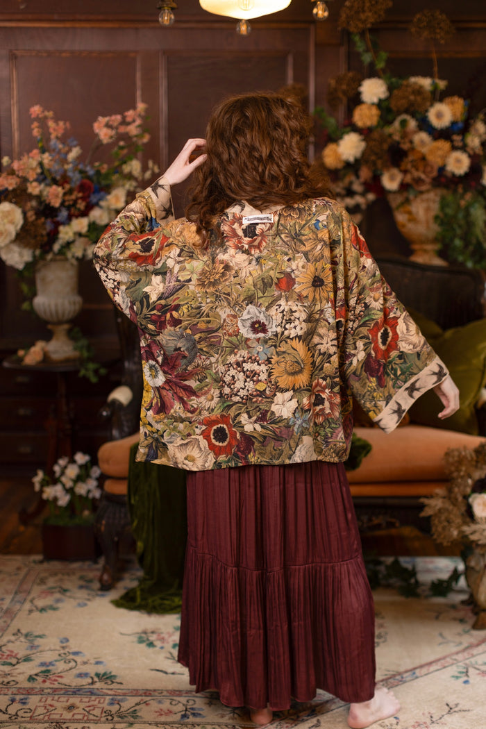 Model wearing a soft bamboo-viscose cropped duster featuring rich 1700s botanical blooms and swallow trim - Market of Stars