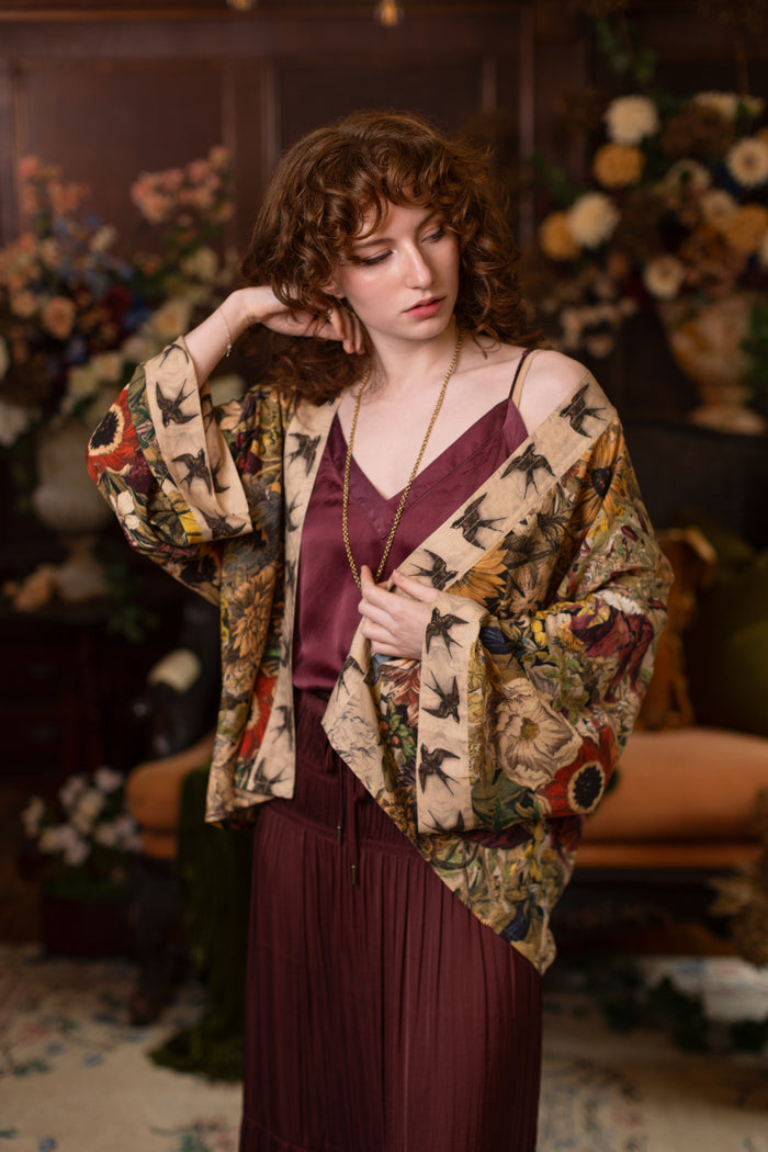 Model wearing a soft bamboo-viscose cropped duster featuring rich 1700s botanical blooms and swallow trim - Market of Stars