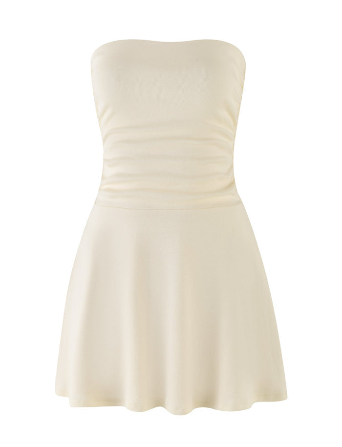 The HARRIETT RIB MINI DRESS in cream from TIGERMIST features a fitted bodice and a flared skirt. The smooth fabric is slightly gathered at the waist in this strapless design, set against a plain white background.