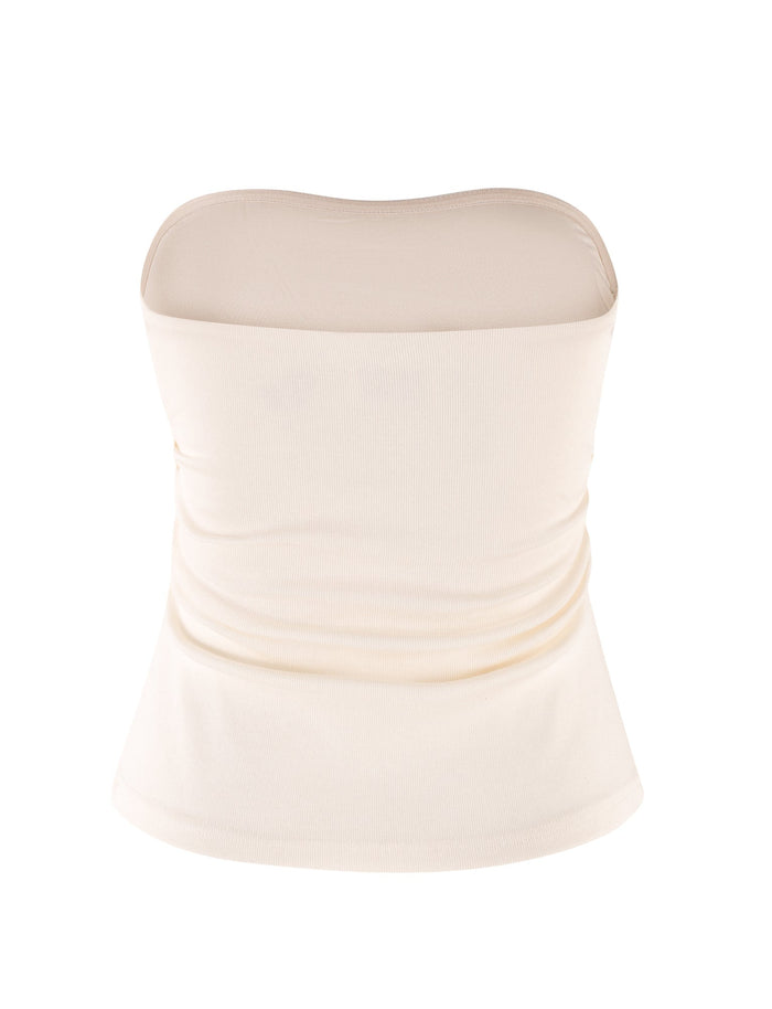 The HARRIETT RIB TUBE TOP - WHITE : CREAM by TIGERMIST is presented on a plain white background. The fabric seems smooth with subtle horizontal ruching on the sides, which creates a bodycon silhouette that hugs the waist. The top gently flares out at the bottom, adding an elegant touch.