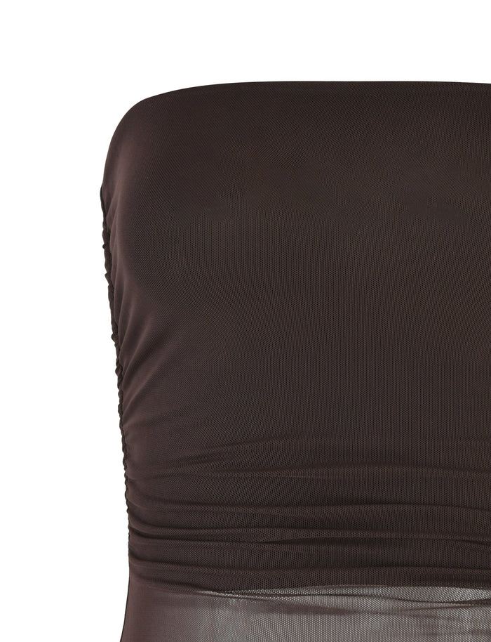 Close-up of the TIGERMIST Harriett Tube Top in Chocolate, a strapless brown outfit featuring a bodycon fit with ruching on the left side. The fabric looks smooth and slightly shiny, crafted with mesh for added stretch and style.