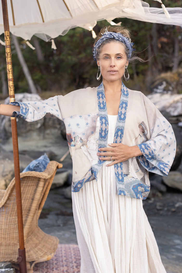 Model wearing the Head in the Clouds Opera Duster featuring Liotard’s portrait of his wife with Turkish textiles, starry sleeves, and poetic script – Market of Stars.