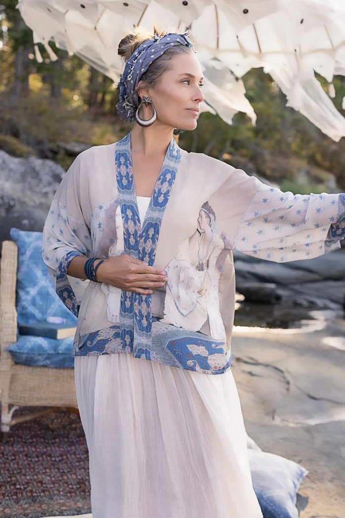 Model wearing the Head in the Clouds Opera Duster featuring Liotard’s portrait of his wife with Turkish textiles, starry sleeves, and poetic script – Market of Stars.