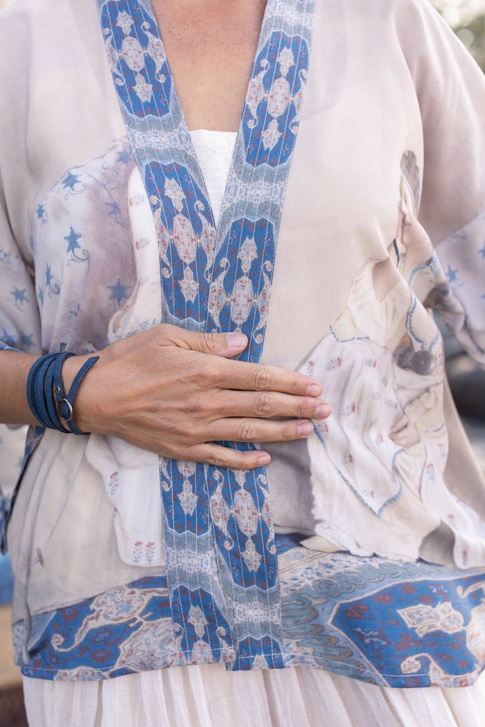 Model wearing the Head in the Clouds Opera Duster featuring Liotard’s portrait of his wife with Turkish textiles, starry sleeves, and poetic script – Market of Stars.