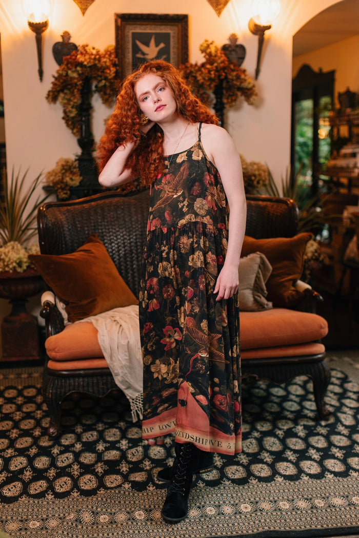 Model wearing a maxi-length bamboo-viscose slip dress featuring a collage of antique artwork with romance, loyalty, and old-world beauty - Market of Stars
