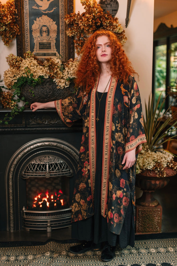 Model wearing a full-length bamboo-viscose duster featuring a collage of antique artwork with romance, loyalty, and old-world beauty - Market of Stars