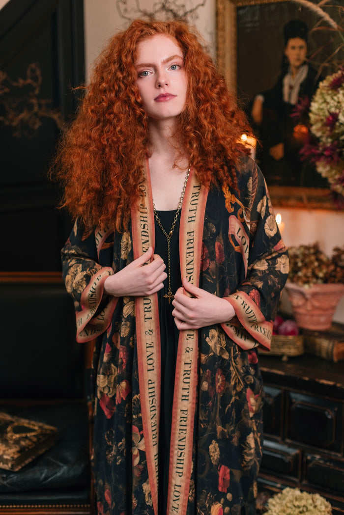 Model wearing a full-length bamboo-viscose duster featuring a collage of antique artwork with romance, loyalty, and old-world beauty - Market of Stars