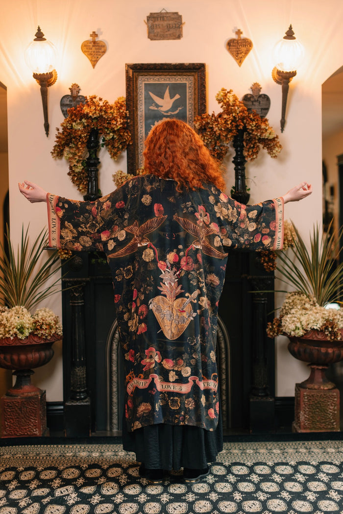 Model wearing a full-length bamboo-viscose duster featuring a collage of antique artwork with romance, loyalty, and old-world beauty - Market of Stars