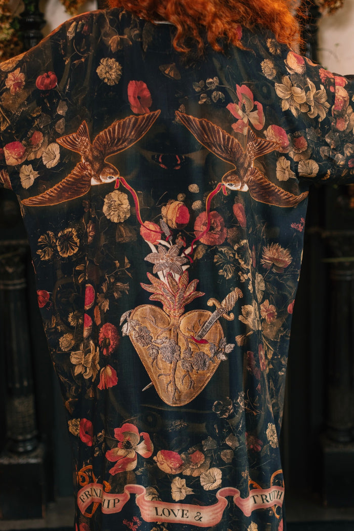 Model wearing a full-length bamboo-viscose duster featuring a collage of antique artwork with romance, loyalty, and old-world beauty - Market of Stars