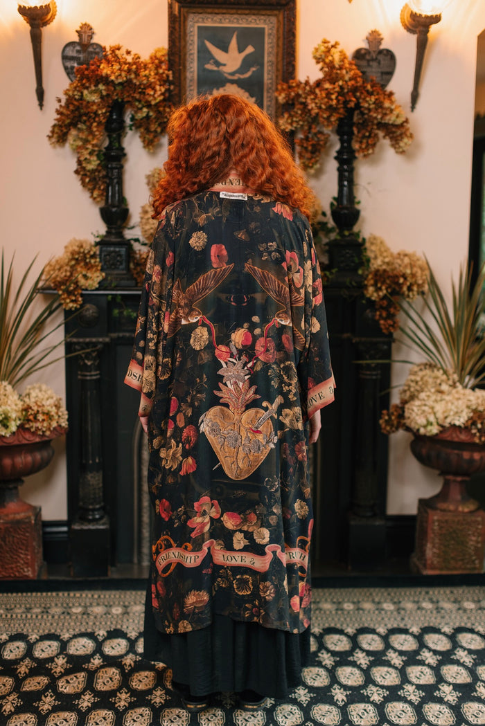 Model wearing a full-length bamboo-viscose duster featuring a collage of antique artwork with romance, loyalty, and old-world beauty - Market of Stars