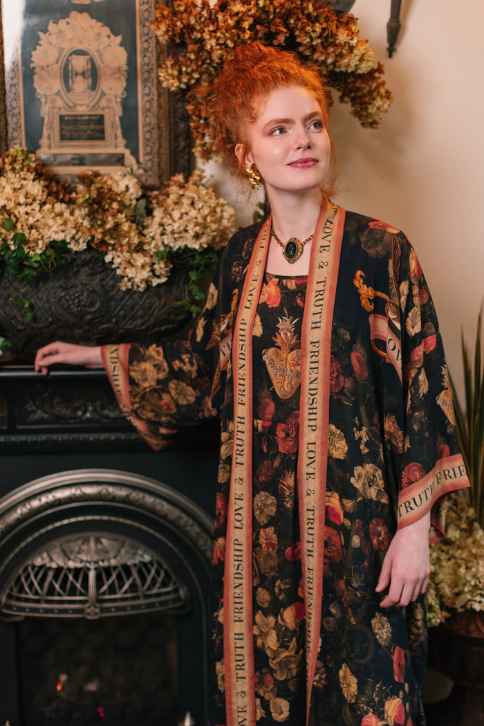 Model wearing a full-length bamboo-viscose duster featuring a collage of antique artwork with romance, loyalty, and old-world beauty - Market of Stars