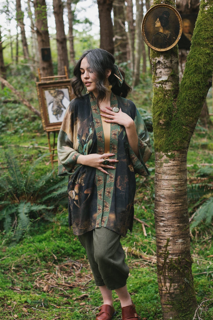Model wearing the Heartwork Cropped Kimono featuring Artemisia Gentileschi’s self-portrait with lush forest, birds, and butterflies – Market of Stars.